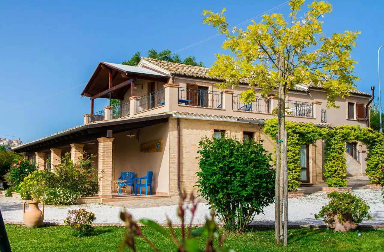 Villa con portico in mattoni, terrazza e sedie blu